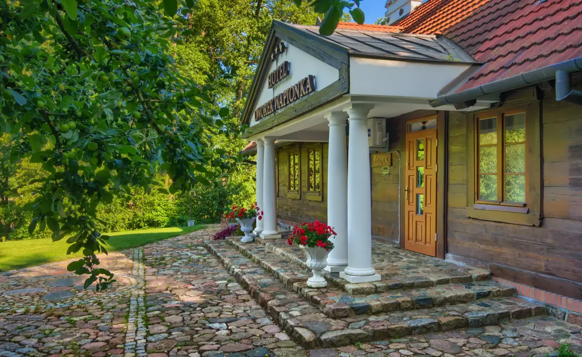 Edificio histórico del Hotel Dworek Wapionka rodeado de vegetación